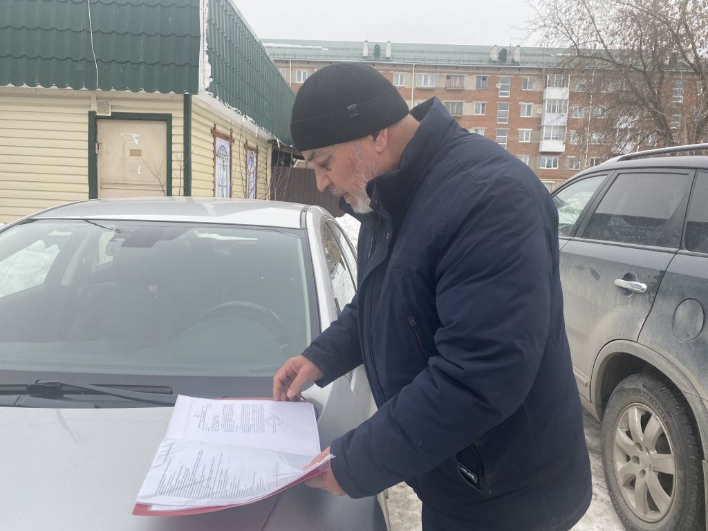 Мамадрахим Сафиев показал документы, подтверждающие право собственности на павильон. Фото: Анна Куприянова, "Глобус"