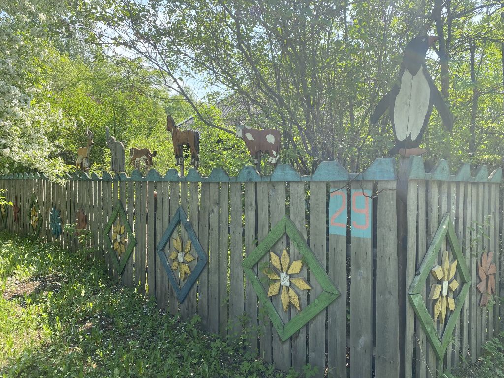 Забор пенсионера украшает деревянные фигурки. Фото: Анна Куприянова, "Глобус"