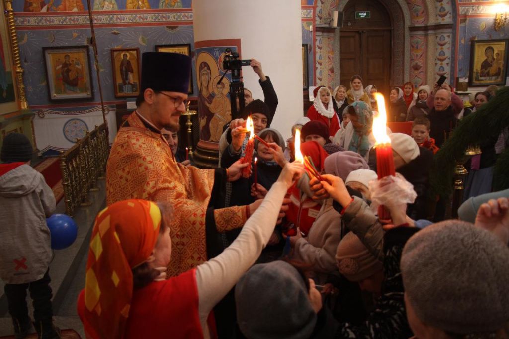 Люди передавали друг другу благодатный огонь, взятый со свечей отца Симеона. Фото: Константин Бобылев, "Глобус"
