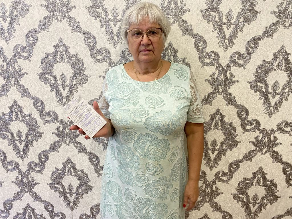 Елена Макарова переживает за состояние матери. В руках женщина держит талон, в котором указано, что ограждения у ямы не было. Фото: Анна Куприянова, "Глобус"