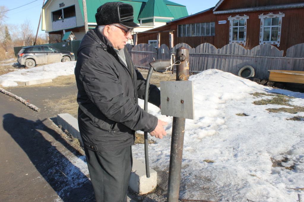 Анатолий Червяков рассказывает, что колонку зимой каждый день приходиться отогревать, прежде чем набрать воды.Фото: Мария Чекарова, "Глобус".