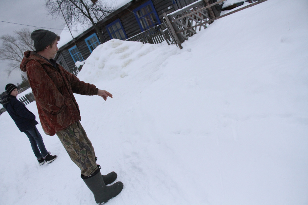Мужчина показывает следы хищника рядом со своим домом. Фото: Константин Бобылев, "Глобус"