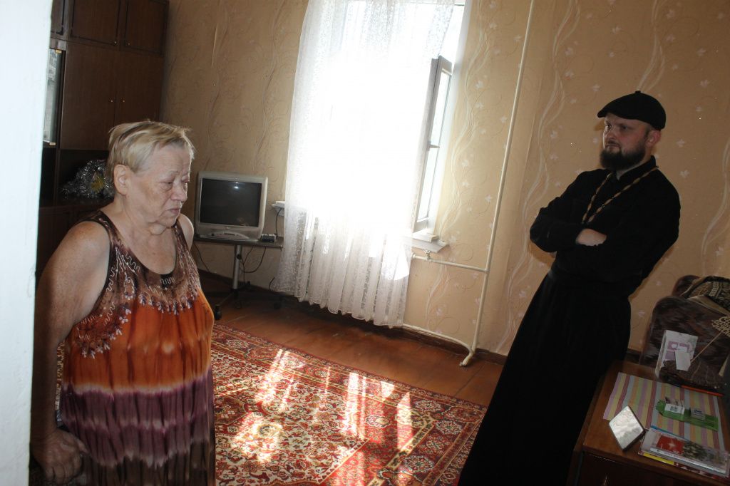 Отец Алексий пообещал Галине Васильевне, что в ближайшее время добровольцы помоют окна. Фото: Мария Чекарова, "Глобус"