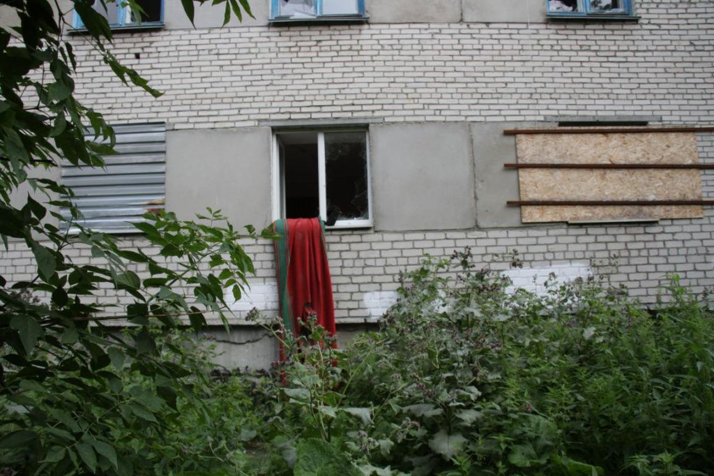 В окно первого этажа в первом подъезде, где взорвался газ, залазят с помощью ковровой дорожки. Фото: Константин Бобылев, "Глобус"