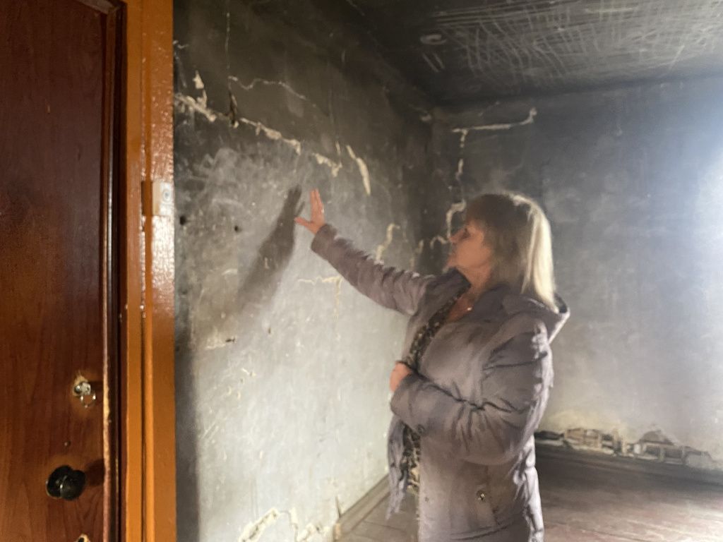 Лариса Казакова пояснила, что когда-то в доме был пожар, поэтому стены подъезда покрыты слоем сажи. Фото: Анна Куприянова, "Глобус"