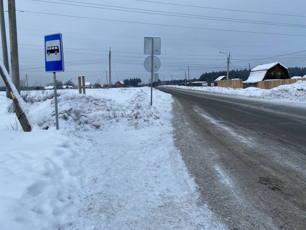 Следы на снегу оставляет не только автобус, но и заезжающие одной стороной на остановку машины.