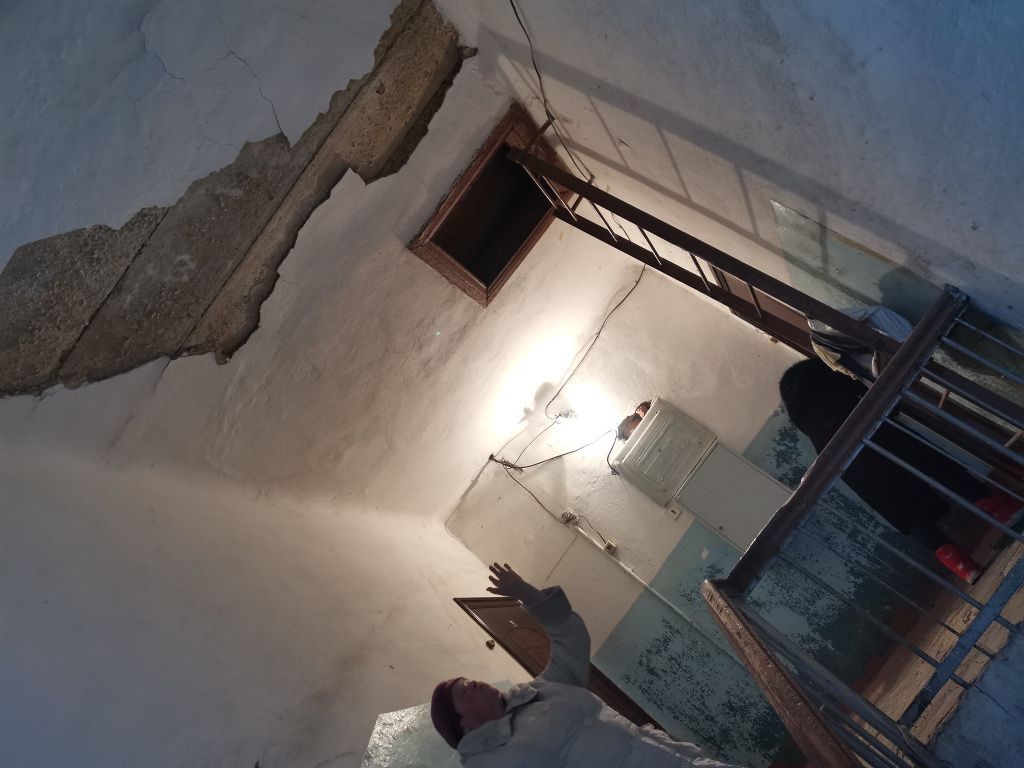 Любовь Кириллова показывает на потолок в подъезде и радуется, что штукатурка не упала на детей. Фото: Константин Бобылев, "Глобус"