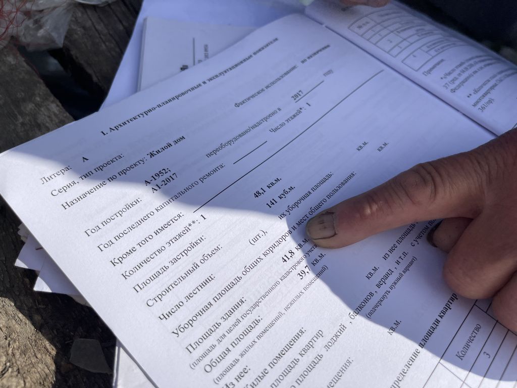 Женщина сравнивает площадь жилья в документах мэрии с паспортом из БТИ.. Фото: Анна Куприянова "Глобус"