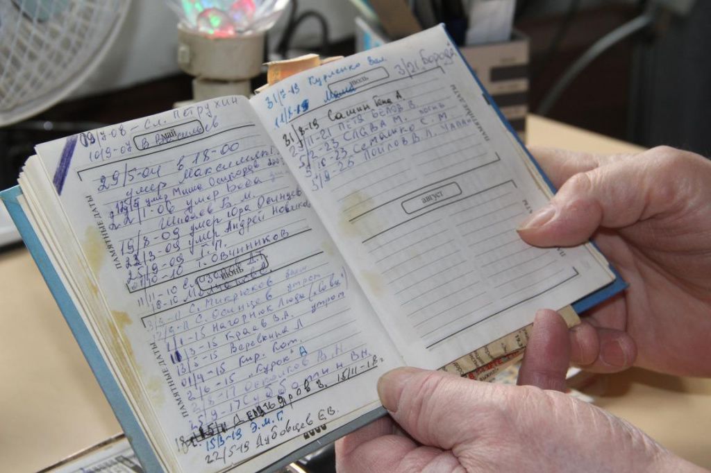 В блокноте Борис Новиков записывает имена умерших чернобыльцев. Фото: Анна Куприянова, "Глобус"