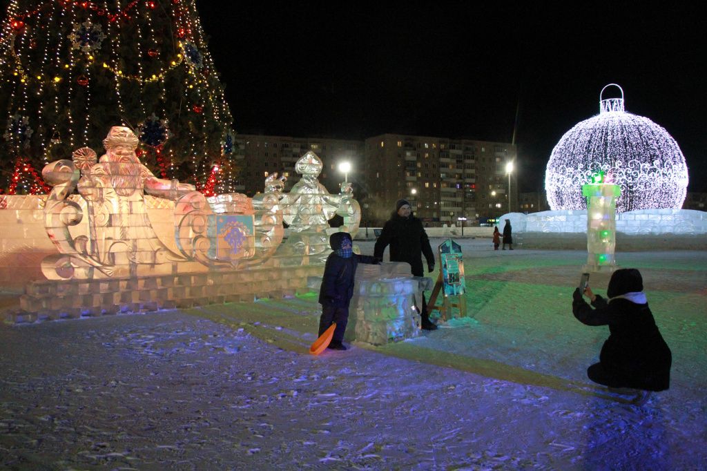 Семья Касьяновых фотографируется на фоне Деда Мороза и елки. Фото: Константин Бобылев, "Глобус"