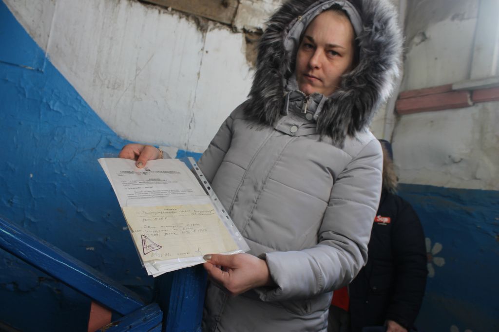 Жительница дома Олеся Шутова показывает ответы и справки за все годы обращений. Фото: Мария Чекарова, "Глобус"