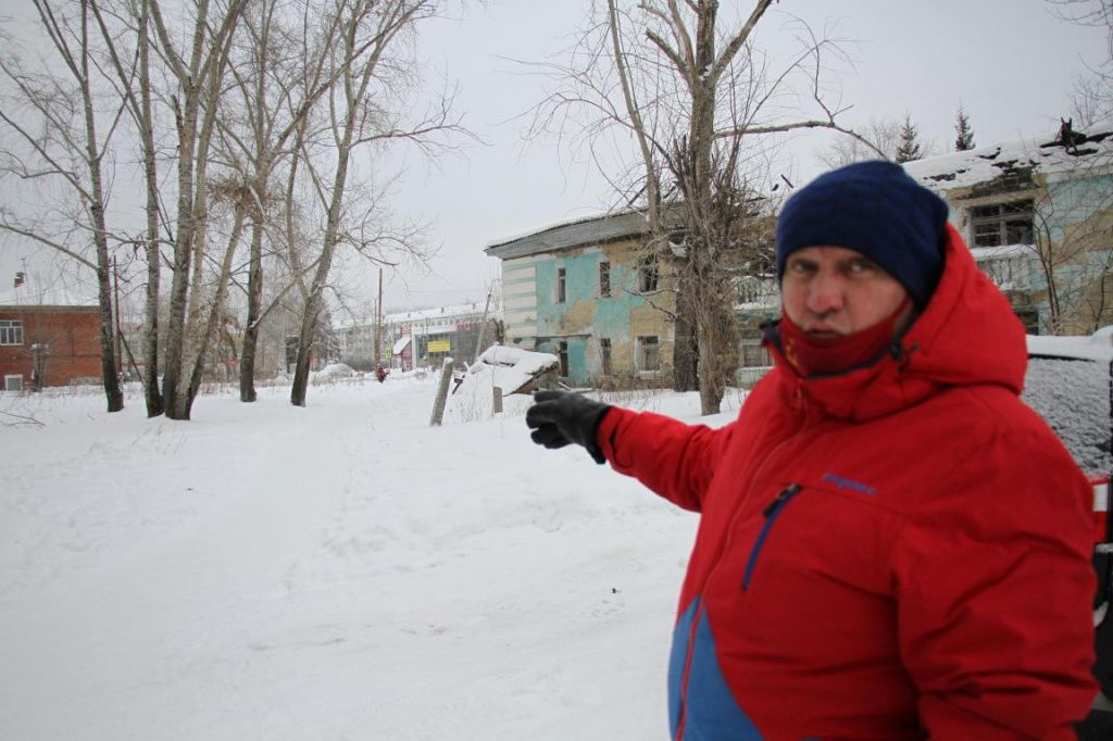 Николай Замиралов показывает на тропку, по которой ходят многие жители поселка Энергетиков - кто в магазин, кто в школу. Поход может закончиться веткой тополя, упавшей на голову. Фото: Константин Бобылев, "Глобус"
