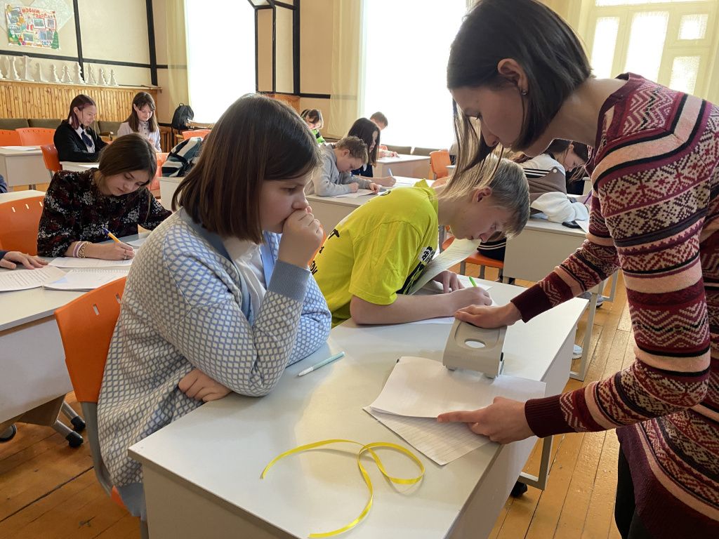 Дина Артемкина оформляла исписанные школьниками листы в книгу. Фото: Анна Куприянова, "Глобус"