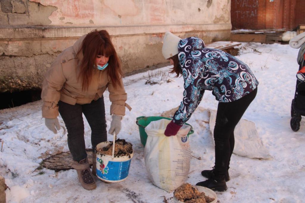 Не дождавшись помощи от "управляшки" люди сами убирают опил из подвала дома. Фото: Анна Куприянова, "Глобус"