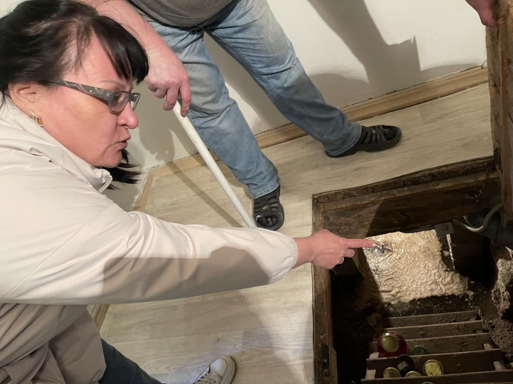 Мария Рахматулина показала, откуда льется вода в подполье. Фото: Анна Куприянова, "Глобус"