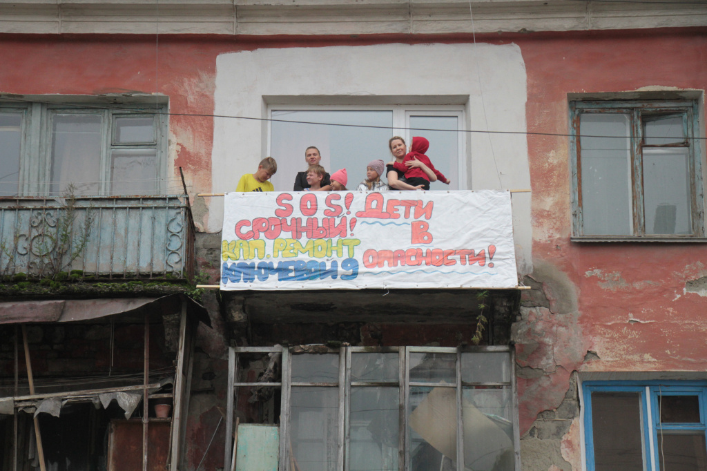 Люди вывесили плакат с призывом о помощи. Фото: Константин Бобылев, "Глобус".