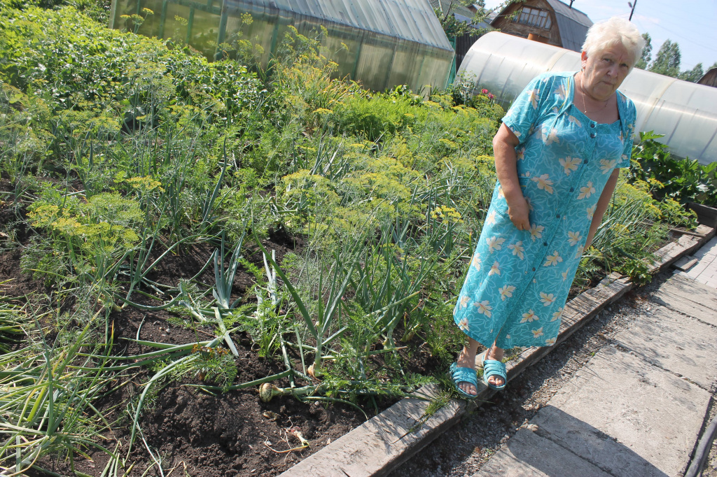 Ольга Петровна расстроена из-за испорченного урожая лука и чеснока. Фото: Мария Чекарова, "Глобус"