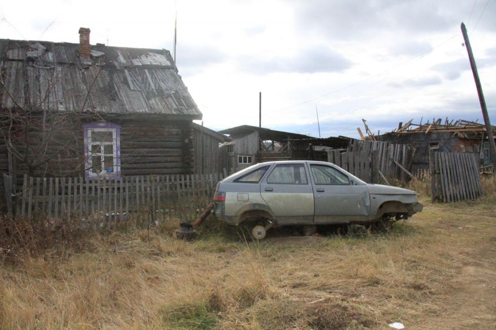 Автомобиль без колес "припаркован" возле дома. Здесь, говорят, живет один из бывших обитателей колонии. Фото: Константин Бобылев, "Глобус"