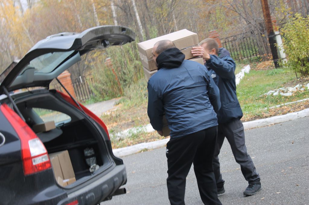 Дмитрий Самсонов и Андрей Пелевин разгружают машину с подарками для пенсионеров. Фото: Мария Чекарова, "Глобус"