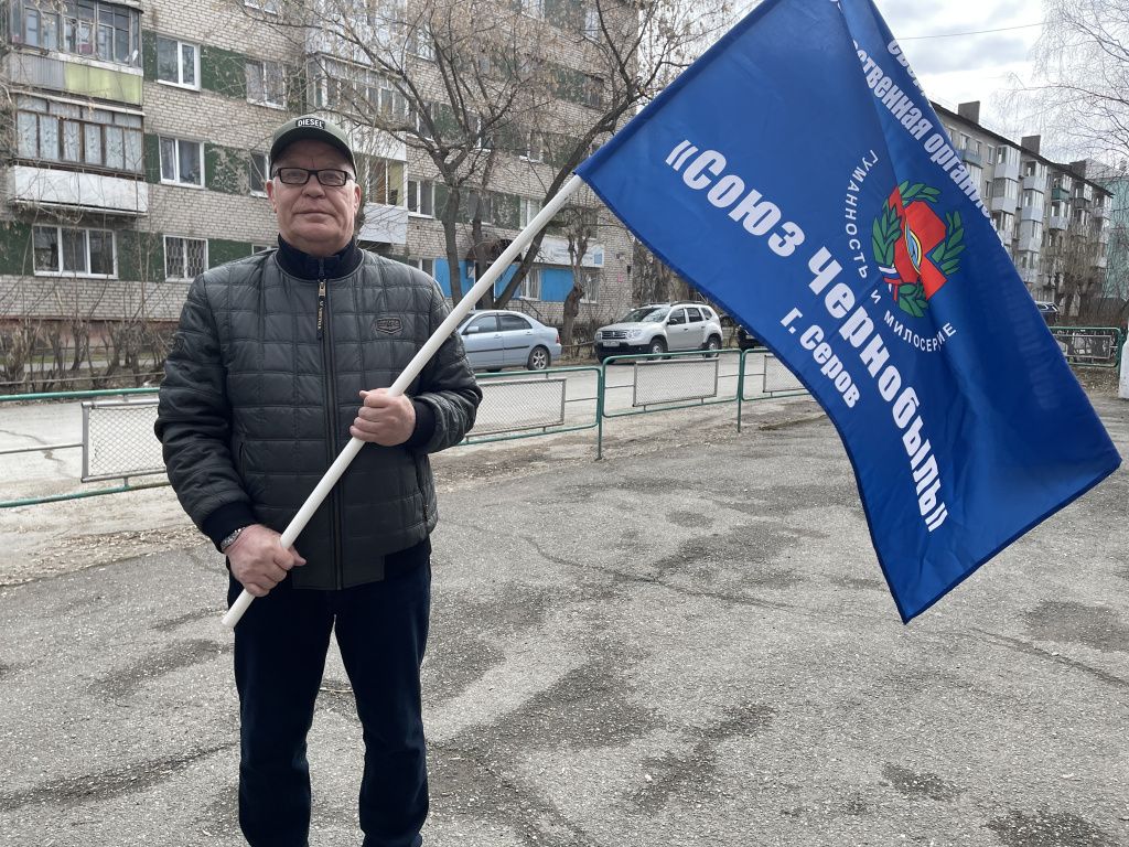 В руках председателя первичной организации союза “Чернобыль” Владимира Киселева флаг сообщества. Фото: Анна Куприянова, "Глобус"