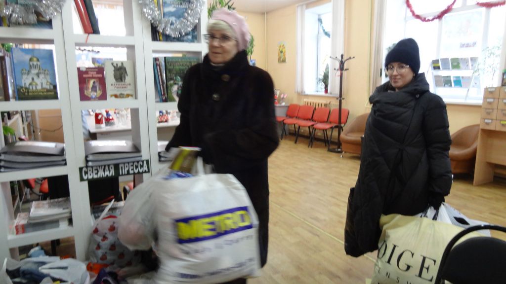 Ольга Леонидовна Набиуллина с помощницей забирает пакеты с вещами из библиотеки. Фото: Марина Демчук, "Глобус"