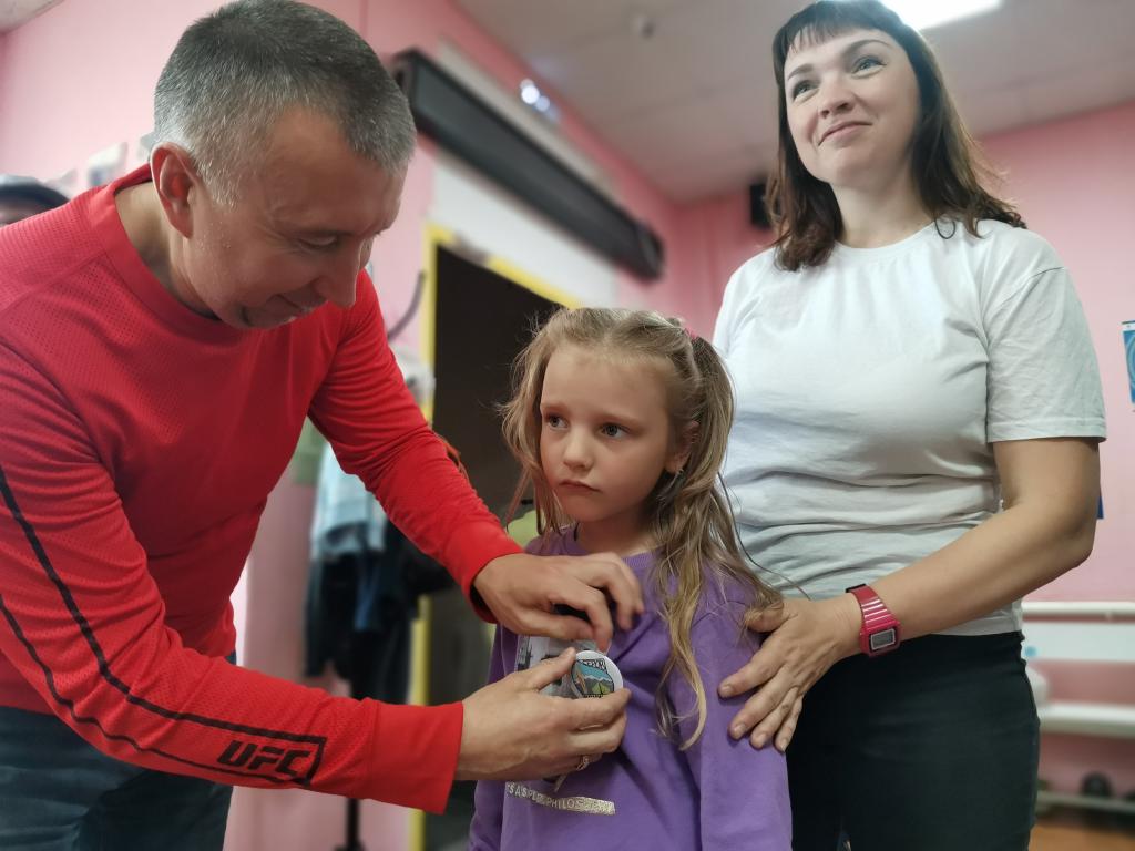 5-летняя Маша Замятина оказалась самой юной участницей прогулки. Сергей Кауров прикрепил к ее кофте значок турклуба. Фото: Константин Бобылев, "Глобус"