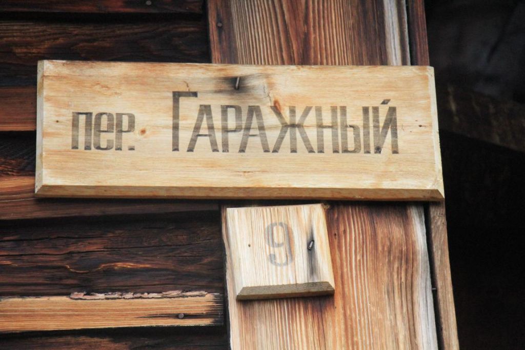 Таблички с названиями улиц - деревянные. Обилие деревянных изделий - характерная черта поселков при уральских колониях. Фото: Константин Бобылев, "Глобус"